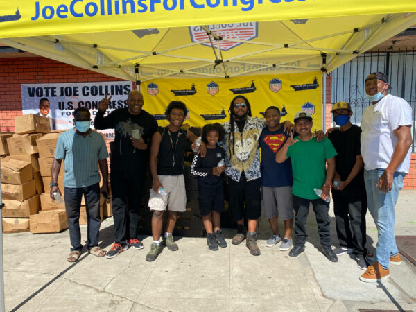 CAMPAIGN TENT WITH MEN STANDING UNDER