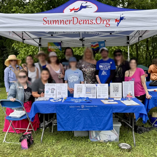 VOLUNTEERS UNDER A BLUE AND WHITE TENT